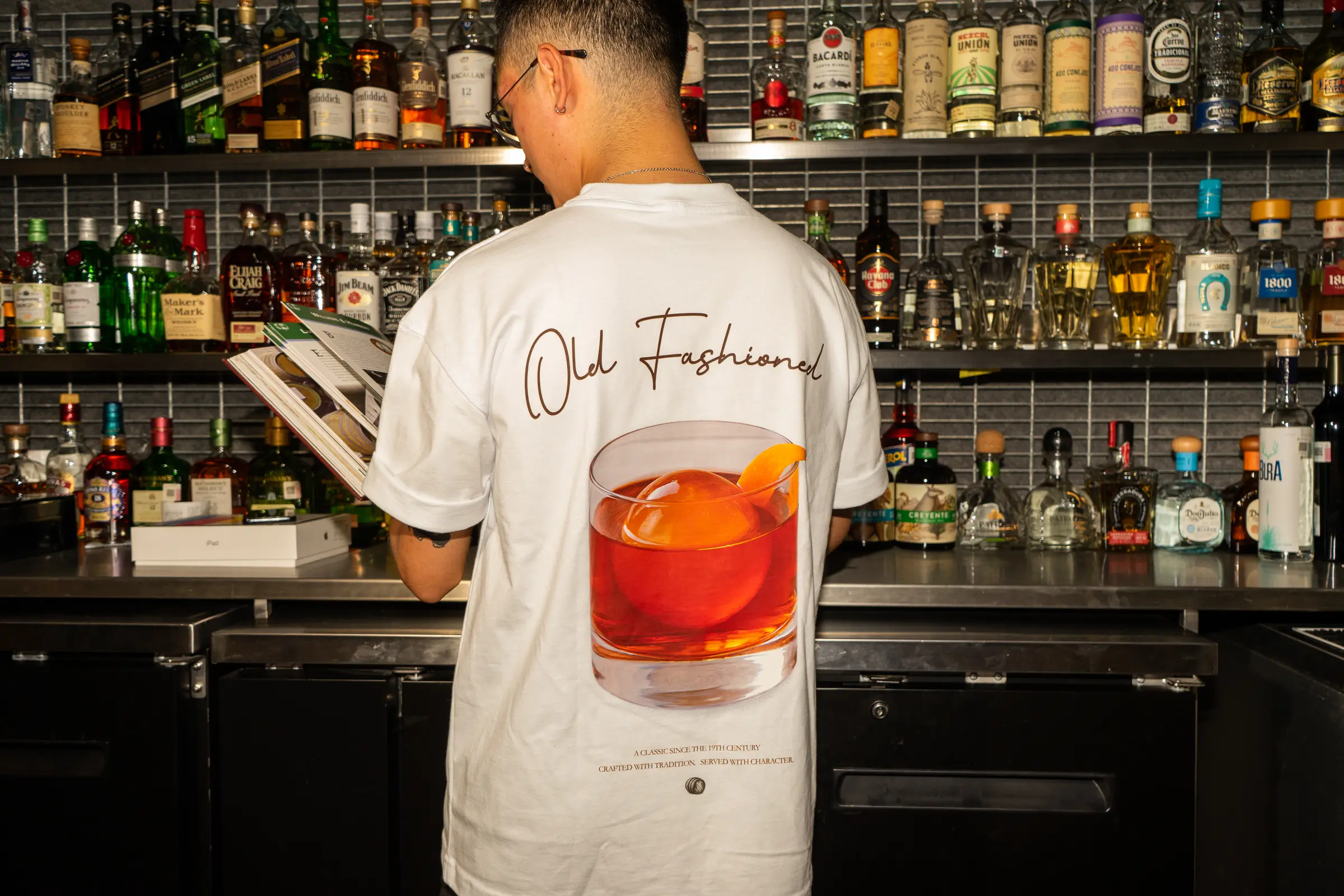Bartender con la playera Old Fashioned frente a la barra